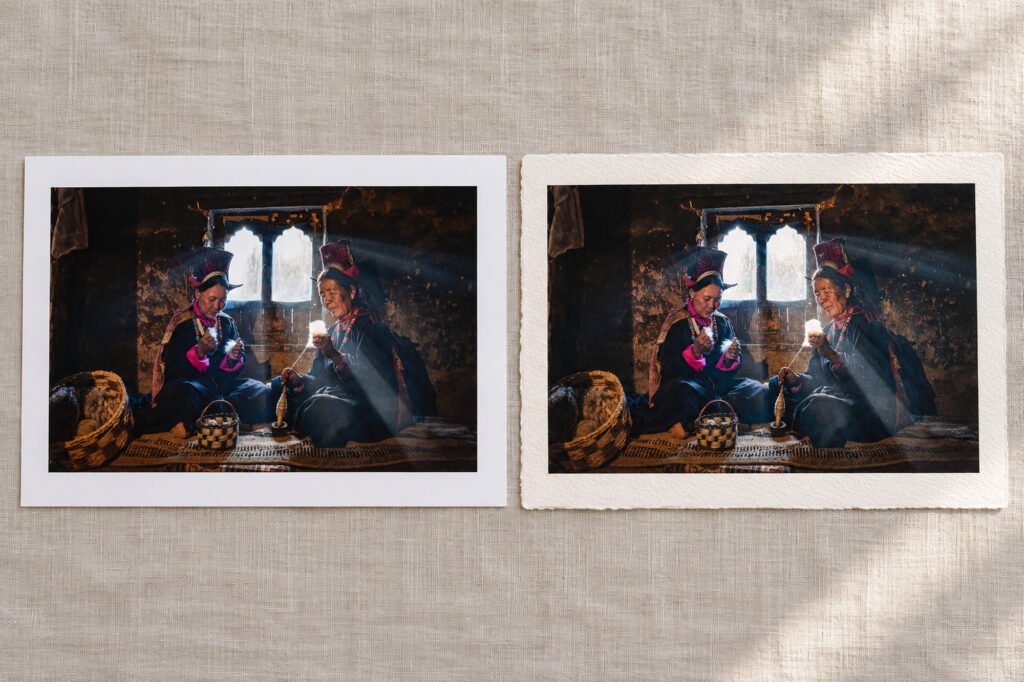Smooth and textured fine art paper samples side by side, each carrying the same mountain photograph